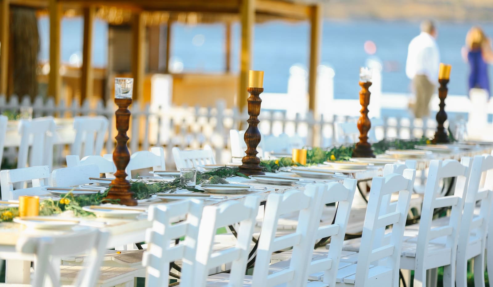 An outdoor wedding reception set up with string lights and decorated tables